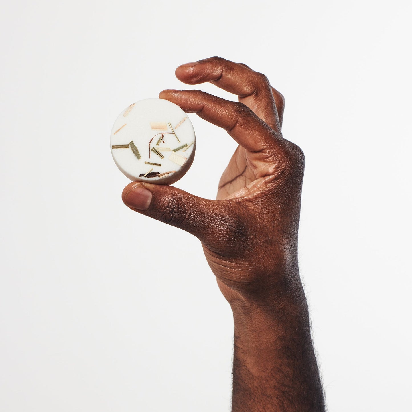 Sunday Steam Clarity shower steamer with lemongrass and bergamot held in hand against a clean white background.